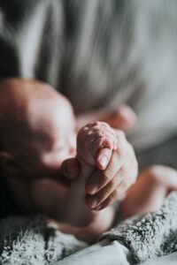 baby grasping adult hand