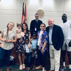 Image of the family on adoption day with the judge